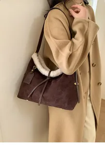 Close-up of vintage brown suede tote bag featuring white faux fur trim and bow detail