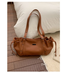 Close-up of brown vintage tote bag with lychee texture leather and drawstring detail