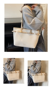 Détail d'un sac cabas blanc à grain litchi avec boucles en métal et texte imprimé