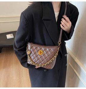 Detail view of brown quilted leather bag with gold rotary lock and glossy finish