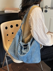Grand sac cabas en jean vintage porté par un mannequin dans un style urbain moderne