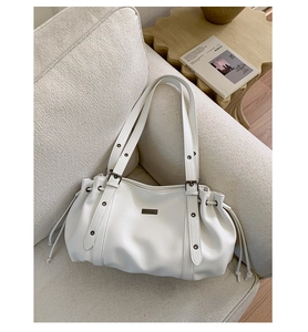 Detail of white lychee leather texture and metal rivets on a stylish bowling tote bag