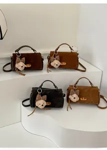 Detailed view of vintage faux suede crossbody bags with metal clasps and plush bear charms