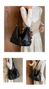 Detail shot of large black tote bag with buckle straps and a brown plush monster charm