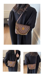 Detailed view of brown quilted crossbody bag with gold chain and rotary lock buckle