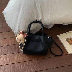 Detail of lychee pattern leather bucket bag with silver buckle and plush bear charm