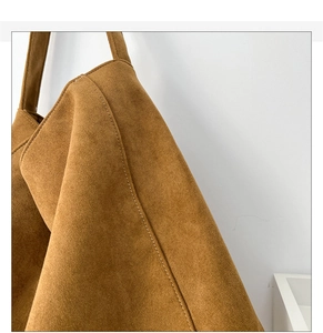 Gros plan du sac cabas en daim marron caramel montrant la texture mate et les coutures