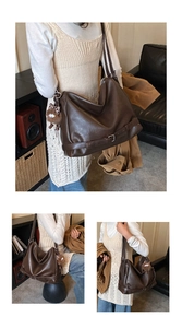 Detail of dark brown leather shoulder bag featuring decorative silver buckle and plush charm