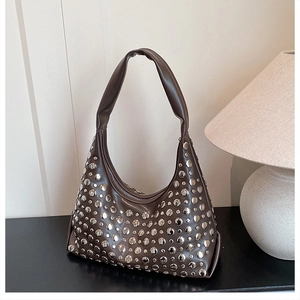 Close-up of brown leather hobo bag featuring vintage silver studs and punk rock detailing