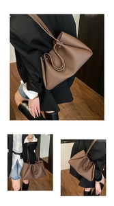 Detail view of coffee brown lychee grain leather tote bag with pleated design details
