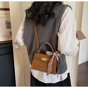 Brown suede crossbody bag with vintage metal lock and decorative silk scarf detail