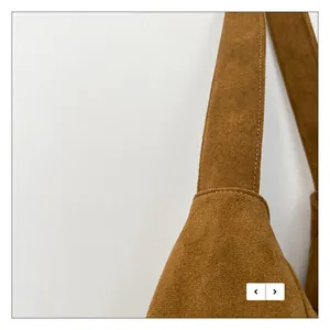 Gros plan sur le sac fourre-tout en daim marron montrant les coutures et la bandoulière