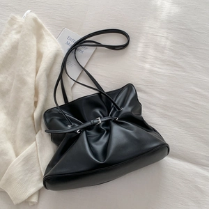 Detail of black pleated tote bag with adjustable silver buckle and cloud texture