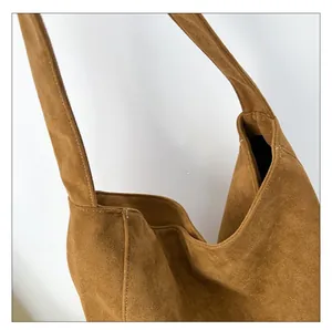 Gros plan détaillé du grand sac cabas en daim caramel montrant sa texture mate et douce