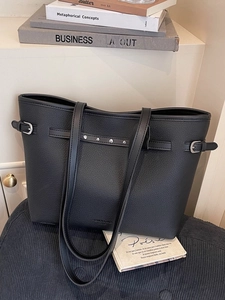 Grand sac cabas noir minimaliste en cuir grainé avec rivets sur un siège bleu