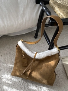 Brown suede hobo tote bag with white faux fur trim and geometric embossed pattern