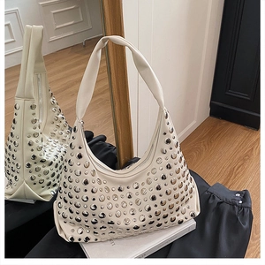 Detail of off-white hobo bag with silver metallic studs and crescent moon shape
