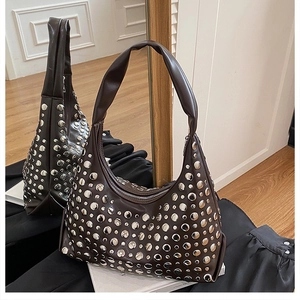 Close-up of brown leather hobo bag featuring polished silver round metal rivet details