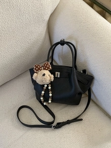 Black lychee texture leather bucket bag with plush bear charm and crossbody strap
