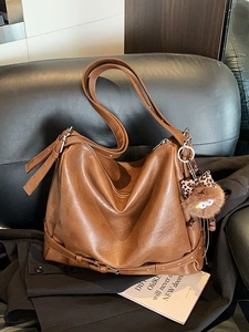 Minimalist caramel brown retro hobo shoulder bag in soft leather with plush charm