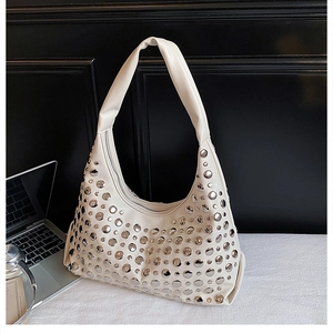 Detail of silver rivets on cream PU leather Hobo shoulder bag with metallic zipper