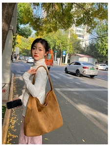 Sac hobo en daim marron présenté en mode rue pour le style de transport quotidien spacieux