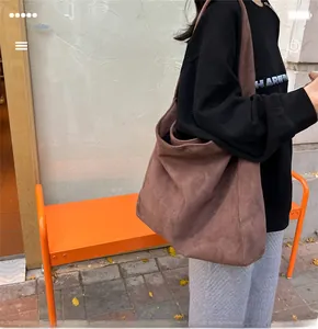 Gros plan d'un grand sac cabas en daim marron dans un décor extérieur automnal