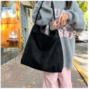 Détail du grand sac cabas en daim noir mat avec une texture épaisse et souple