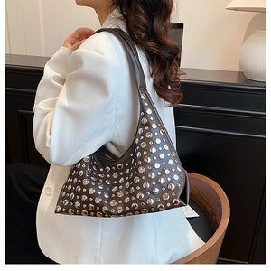 Detail of dark brown leather hobo bag with silver rivet studs and stylish shoulder strap
