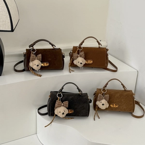 Detailed display of vintage suede handbags in four colors with plush bear charms