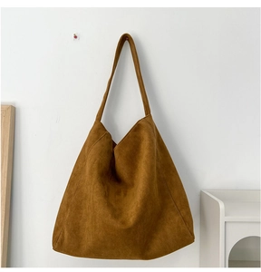 Détail du sac hobo en daim caramel montrant la texture douce et le drapé naturel élégant