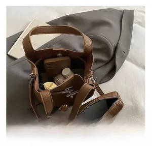 Détail de l'intérieur spacieux du sac seau en cuir grainé marron avec pochette interne