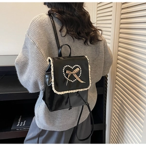 Détails de perles en cœur, dentelle et nœud à carreaux sur sac à dos noir