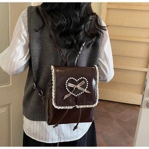 Détail du sac à dos vintage en cuir PU marron avec dentelle et nœud en cœur de perles
