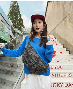 Detail of camouflage chest bag with triple zipper pockets and durable canvas texture
