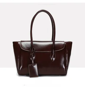 Detailed front view of coffee brown faux leather tote bag with glossy finish and tag