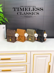 Detail of four colorful mini shoulder bags with knotted straps and plush eye charms