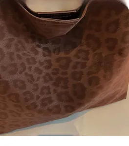 Gros plan du sac cabas léopard montrant la texture en daim et les motifs animaliers