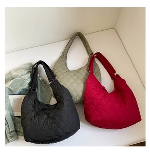 Detailansicht von drei gesteppten Hobo-Taschen in Schwarz, Grün und Rot