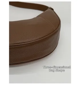 Detail of 3D structured dark brown dumpling bag featuring premium pebble leather texture