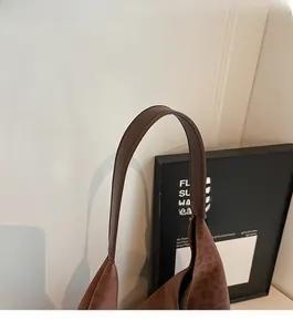 Détail de la bandoulière marron foncé et de la texture léopard sur le sac à bandoulière
