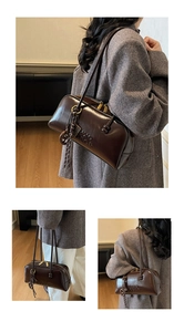 Detail of dark brown glossy leather bowling bag featuring embossed logo and tassel charm