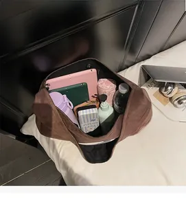 Top view of the spacious interior of this large brown suede tote bag holding a tablet