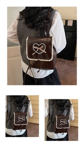 Close-up of pearl heart and plaid bow detail on a brown lace-trimmed backpack