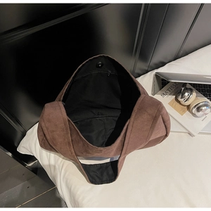 Interior view of large brown suede tote bag showing magnetic buckle and inner zipper pocket