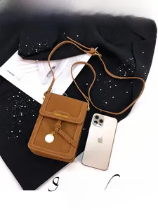 Detailed view of brown matte small crossbody bag with metal ring and tassel detail