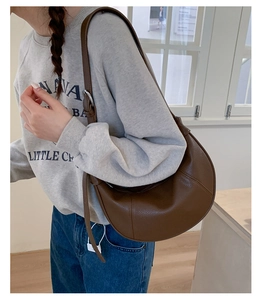 Detail view of deep brown pebbled leather crescent hobo bag with adjustable buckle strap