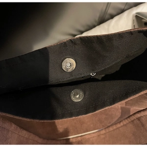 Detail of suede tote bag showing magnetic snap closure and black interior lining