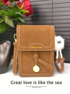 Brown litchi leather phone bag with gold metal pendant and fluffy monster charm