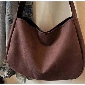 Detailed view of large dark brown suede tote bag with textured matte finish and black lining